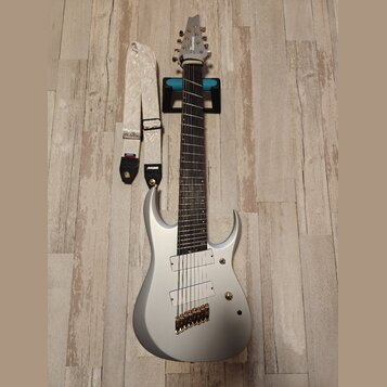 Stříbrná elektrická kytara s dvojsečným výřezem korpusu a šesti strunami. Na hlavě je viditelný nápis Ibanez. Kytara má dva humbuckery, zlatý most a…