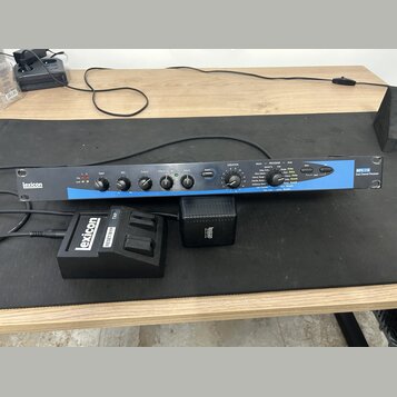 Černý rackový efektový procesor s modrým pruhem a nápisy Lexicon a MFX 116 Dual Channel Processor. Zařízení obsahuje řadu ovládacích knoflíků, přepín…
