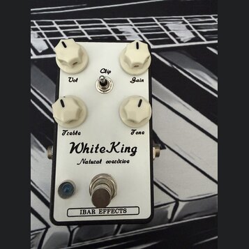Bílý efekt pedál s nápisy WhiteKing a Natural overdrive. Obsahuje čtyři bílé otočné knoflíky s popisky Vol, Gain, Treble a Tone, jeden přepínač Clip…