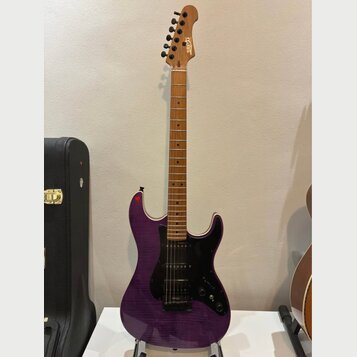 Fialová elektrická kytara s tmavým hmatníkem a černým pickguardem. Na hlavě je viditelné zlaté logo „Squier“. Tělo má lakovaný povrch s viditelnou st…