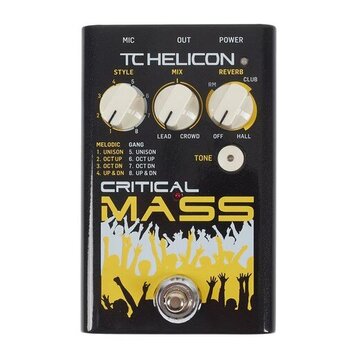 Černý efekt pedál s nápisy TC HELICON a CRITICAL MASS. Na horní části jsou tři bílé otočné ovladače s popisky STYLE, MIX a REVERB. Pod nimi je bílé t…
