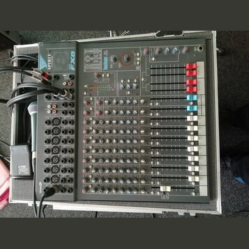Šedý míchací pult s nápisy SPIRIT a FX8 umístěný v transportním kufru. Zařízení obsahuje řadu regulačních potenciometrů, posuvníků a vstupních konekt…