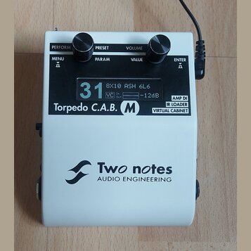 Bílý kytarový procesor Torpedo C.A.B. M od značky Two notes AUDIO ENGINEERING. Zařízení má digitální displej s nápisy 31, 8X10 ASH 6L6, VC In Out a -…