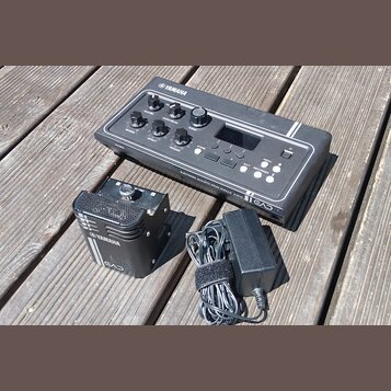 Černý elektronický modul s nápisy YAMAHA, ELECTRONIC ACOUSTIC DRUM MODULE EAD10 a logem EAD. Zařízení obsahuje několik otočných ovladačů, tlačítka ST…