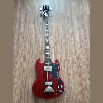Červená elektrická basová kytara s tmavým hmatníkem a černým pickguardem. Na hlavě je bílý nápis Epiphone. Nástroj má dva snímače a čtyři ovládací kn…