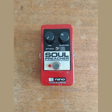 Červený efekt pedál s nápisy SOUL PREACHER a COMPRESSOR/SUSTAINER. Na levé straně je logo nano a text MADE IN NYC USA. Pedál má dva černé ovládací kn…