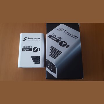 Na fotografii jsou dvě krabice od produktu Torpedo Captor X značky Two notes AUDIO ENGINEERING. Jedna krabice je bílá a druhá černá, obě mají stejný…