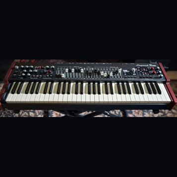 Černý syntetizátor s červenými bočními panely a bílo-černou klaviaturou. V pravém horním rohu je nápis Legend One ANALOG SYNTHESIZER. Horní panel obs…