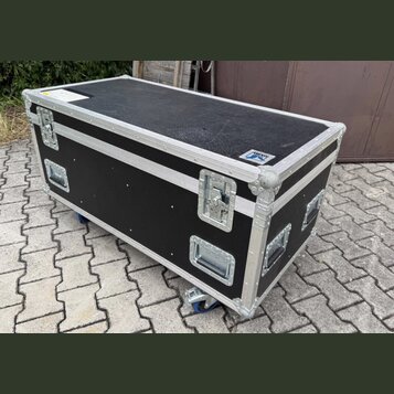 Černý transportní flightcase s hliníkovými hranami a rohy. Na horní hraně je umístěn malý bílo-modrý štítek s nápisem "TOWNSEND". Case je vybaven čty…