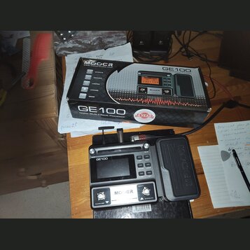 Na fotografii je kytarový procesor efektů MOOER GE100 v originální krabici. Na krabici i na samotném zařízení je uveden název modelu GE100 a značka M…