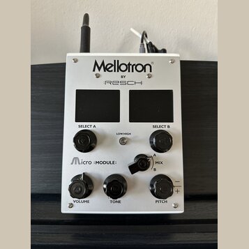 Stříbrný efektový pedál s nápisy Mellotron®, BY :RESCH: a Micro :MODULE:. Zařízení má dvě černé displejní plochy, tři černé otočné knoflíky s popisky…