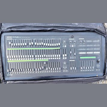 Šedý svítící panel s nápisem SIGM Studio 24 professional light controller. Zařízení obsahuje množství posuvníků, tlačítek a několik otočných ovladačů…