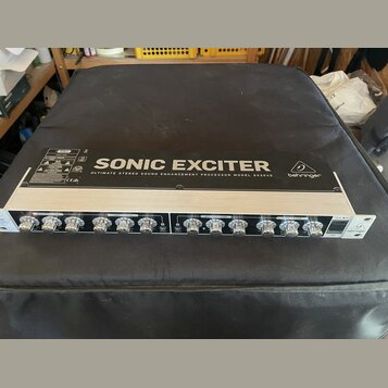Rakový procesor s černým horním panelem a stříbrným předním panelem. Na horní části je bílý nápis SONIC EXCITER, pod ním text ULTIMATE STEREO SOUND E…