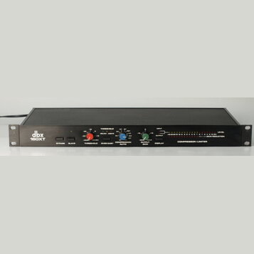 Černý rackový kompresor/limiter značky dbx, model 160XT. Přední panel obsahuje tři otočné ovladače s červeným, modrým a zeleným knoflíkem, dva přepín…
