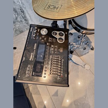 Černý elektronický bicí modul Roland TD-20. Na zařízení je vidět nápis Roland a modelové označení V-Drums SOUND MODULE TD-20. Modul obsahuje několik…