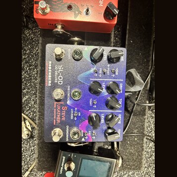 Kytarový efekt pedál s kovovým šasi a fialovo-modrým gradientním povrchem. Na pedálu jsou nápisy RODENBERG, SL-OD DELUXE, CUSTOM AMPLIFICATION a STEV…