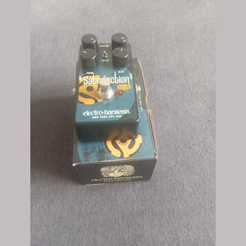Kytarový efekt pedál značky electro-harmonix v černé barvě s modro-žlutým grafickým motivem. Na horní straně jsou tři černé ovládací knoflíky a nápis…