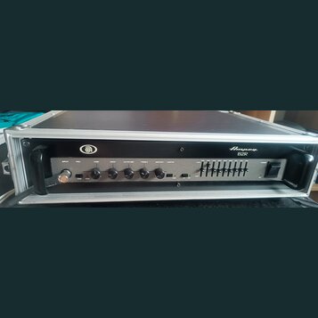 Černý basový zesilovač Ampeg B2R umístěný v hliníkovém transportním kufru. Na předním panelu jsou ovládací prvky s nápisy INPUT, PAD, GAIN, BASS, ULT…