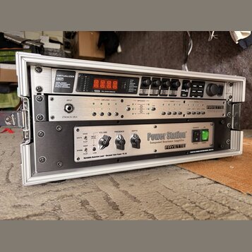 V hliníkovém transportním kufru jsou umístěny tři rackové jednotky. Horní zařízení je stříbrné s nápisy VIRTUALIZER 3D, MODEL P3000 a RSM REAL SOUND…