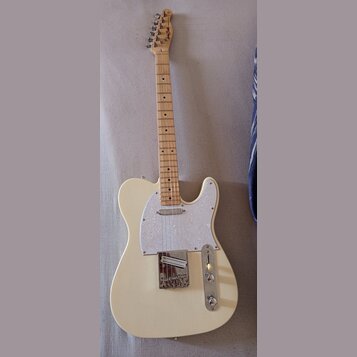 Elektrická kytara s krémovým korpusem, světlou hmatníkovou deskou a bílým perleťovým pickguardem. Na hlavě krku je viditelné logo "Hagstrom". Nástroj…