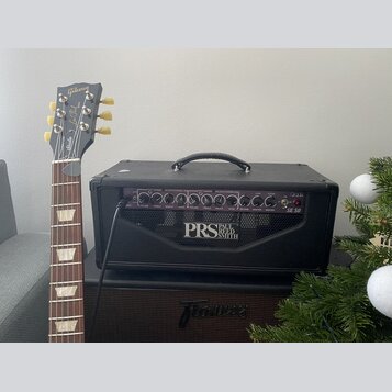 Černý kytarový kombozesilovač s nápisem PRS PAUL REED SMITH a označením SE 50. Na ovládacím panelu jsou knofíky a nápisy jako LEAD CHANNEL, CLEAN CHA…