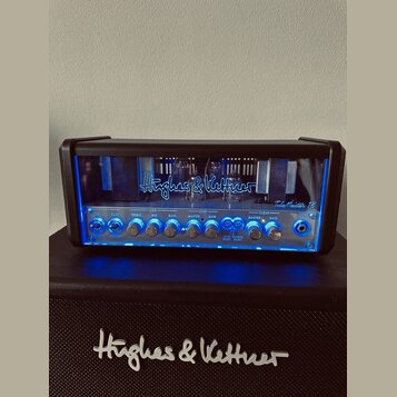 Kytarový zesilovač značky Hughes & Kettner, model TubeMeister 18. Přední panel je vybaven ovládacími knoflíky pro Treble, Mid, Bass, Master Gain a Cl…