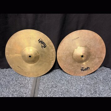 Dvě mosazné činely s viditelným opracováním povrchu. Oba mají nápis 13" Cymbal a logo flash CYMBALS. Povrch pravého činele vykazuje více drobných skv…