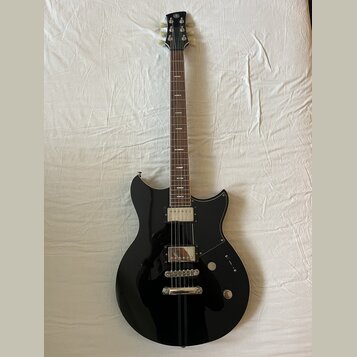 Černá elektrická kytara s tmavým hmatníkem a bílými ladícími kolíky. Na hlavě je viditelné logo Yamaha. Tělo má dva humbuckery, jednu tónovou a jednu…