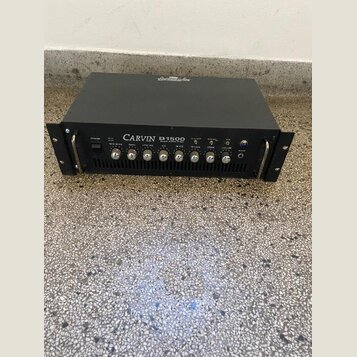 Černý basový zesilovač v rackovém provedení s nápisem CARVIN B1500 BASS AMPLIFIER. Přední panel obsahuje několik ovládacích knoflíků, přepínačů a vst…