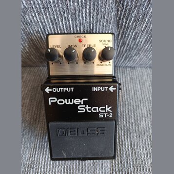 Černý efekt pedál s kovovým horním panelem. Na panelu jsou čtyři ovládací knoflíky s popisky LEVEL, BASS, TREBLE a SOUND DRIVE (s volbou CRUNCH ULTRA…
