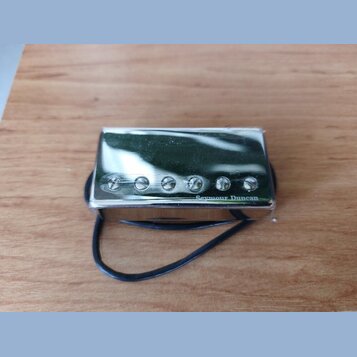 Stříbrný kovový snímač s pěti viditelnými šrouby v řadě. V pravém dolním rohu je nápis Seymour Duncan. Snímač je zabalen v průhledné plastové fólii a…