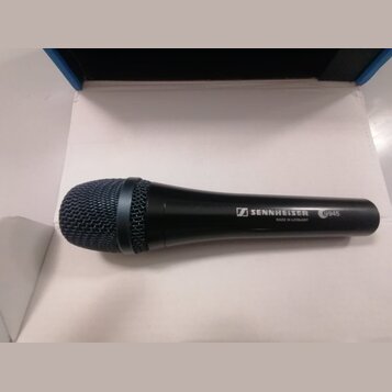 Černý dynamický mikrofon s kovovou síťkou. Na těle je bílý nápis SENNHEISER, označení modelu e945 a drobný text MADE IN GERMANY. Povrch mikrofonu je…