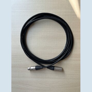 Černý mikrofonní kabel svinitý do kruhu. Na kabelu je bílý nápis PROFESSIONAL MICROPHONE CABLE — BY KLOTZ AUS GERMANY. Kabel má na koncích stříbrné k…