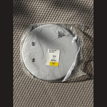 Bílá bubenová koženka v originální plastové obalovce. Na povrchu je logo REMO s nápisem "AMBASSADORS WHITE SUEDE COATED". Na přilepené štítku je uved…