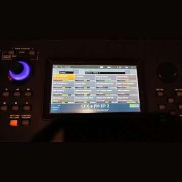 Detailní pohled na displej digitálního klaviru nebo syntezátoru. Na obrazovce je zobrazeno menu s názvem Live Set a seznam presetů v rámci kategorie…