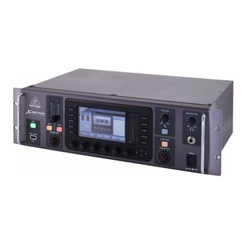 Šedý rackový digitální mixážní pult s kovovým šasi a chromovanými úchyty po stranách. Na předním panelu je nápis behringer a model X32 RACK, centráln…