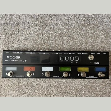 Černý MIDI kontrolér s nápisem MOOER a označením PEDAL CONTROLLER L6. Zařízení má šest stupňovatelných spínačů s barevným podsvícením a čtyři ovládac…