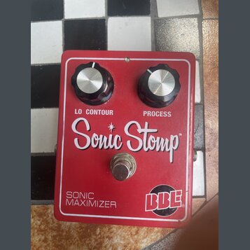Červený kytarový efekt s nápisy LO CONTOUR a PROCESS u dvou černých ovládacích knoflíků. Uprostřed je velký bílý nápis Sonic Stomp a v dolní části te…