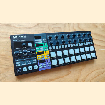 Černý sekvencer značky ARTURIA s nápisem YOUR EXPERIENCE - YOUR SOUND. Zařízení obsahuje několik otočných potenciometrů, bílá tlačítka v mřížce a bar…