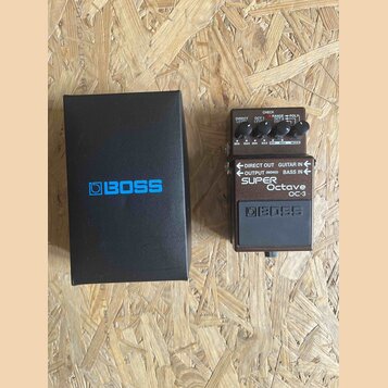 Kutý efekt pedál v hnědé barvě s nápisy DIRECT OUT, GUITAR IN, OUTPUT (MONO), BASS IN a označením SUPER Octave OC-3. Na horní části jsou ovládací prv…