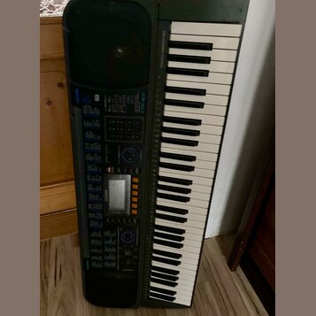 Černý digitální klavír s bílými a černými klávesami. Na levé straně je ovládací panel s displejem, tlačítky a nápisy CASIO a CTK-611. V horní části n…