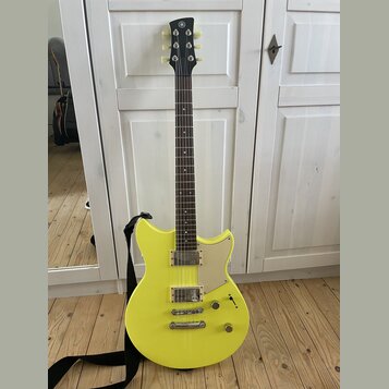 Žlutá elektrická kytara s tmavým hmatníkem a černou hlavou. Na hlavě je viditelné logo Yamaha. Tělo má dva snímače typu humbucker, jeden tónový a jed…