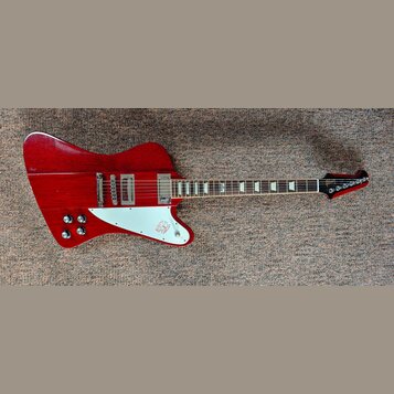 Červená elektrická kytara s bílým pickguardem a dvěma humbuckery. Na hlavě hmatníku je viditelné logo Epiphone. Nástroj vykazuje známky používání v p…