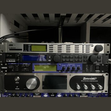 Snímek zachycuje čtyři rackové studiové procesory naskládané nad sebou. Horní zařízení je stříbrné s nápisem tc electronic a modrým logem. Druhý přís…