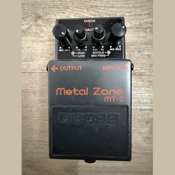 Černý kytarový efekt pedál s nápisy Metal Zone a mt-2 v oranžové barvě a vyraženým logem BOSS. Na pravé straně jsou čtyři ovládací knoflíky a nápisy…