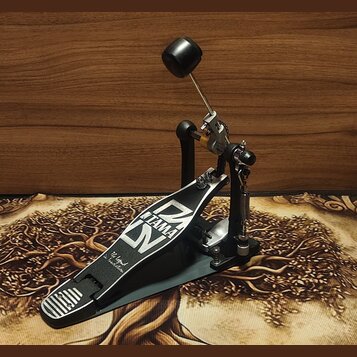 Šedý basový pedál s černými a stříbrnými prvky. Na stupni je bílý nápis TAMA a stylizované logo Iron Cobra, dále text The Legend in Innovation. Povrc…
