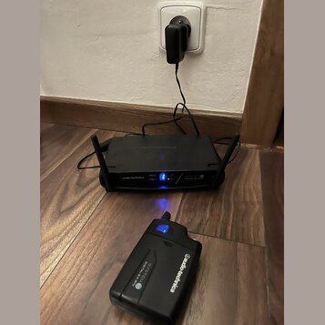 Černý bezdrátový systém značky audio-technica, který se skládá z přijímače a vysílače. Na obou zařízeních je bílý nápis audio-technica a označení SYS…