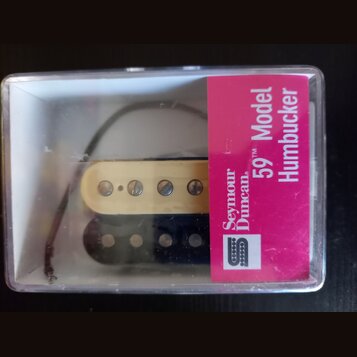 Průhledný plastový obal obsahuje dva humbuckery, jeden v krémové a druhý v černé barvě. Na růžovém štítku je uveden nápis Seymour Duncan 59 Model Hum…
