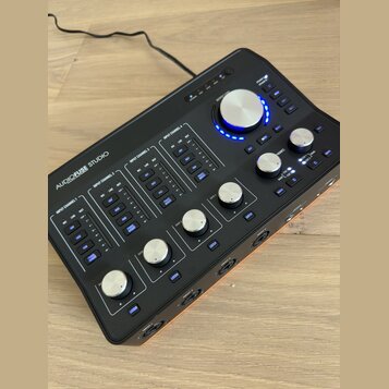 Černý audio rozhraní s nápisem AUDIOFUSE STUDIO. Zařízení obsahuje čtyři vstupní kanály označené jako INPUT CHANNEL 1 až 4, každý s vlastními přepína…