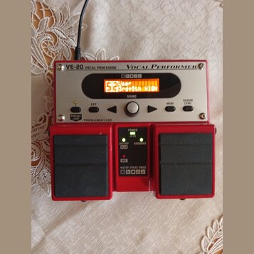 Červený vokální procesor BOSS VE-20 Vocal Performer. Zařízení má digitální displej s oranžovým textem User 52 3rd+5th HIGH a ovládací prvky jako knof…